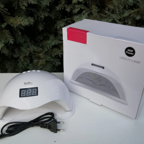 Bela UV LED lampa za nokte 48W na stolu, spremna za profesionalan manikir.