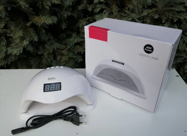 Bela UV LED lampa za nokte 48W na stolu, spremna za profesionalan manikir.
